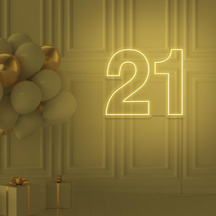yellow 21 neon sign hanging on wall with balloons