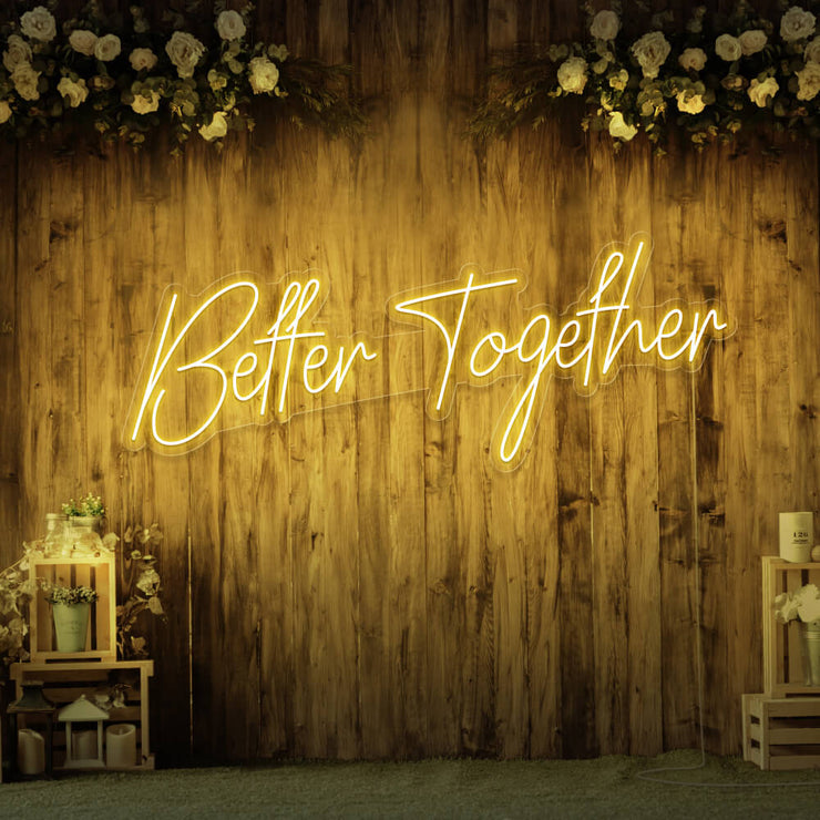 yellow better together neon sign hanging on timber wall