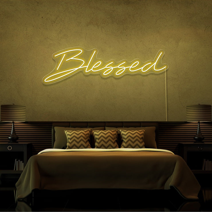 yellow blessed neon sign hanging on bedroom wall