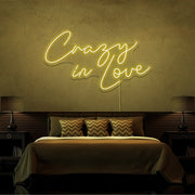 yellow crazy in love neon sign hanging on bedroom wall