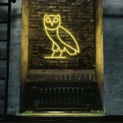 yellow drake ovo owl neon sign hanging on bar wall