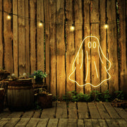 yellow draped ghost neon sign hanging on timber wall