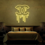 yellow dripping chanel neon sign hanging on bedroom wall