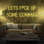 yellow lets fuck up commas neon sign hanging on living room wall