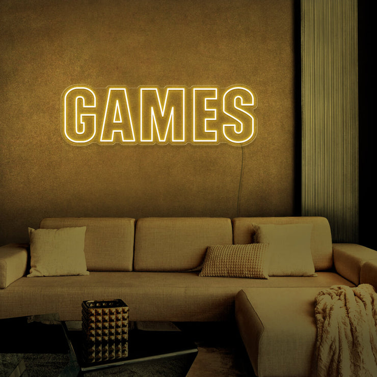 yellow games neon sign hanging on games room wall