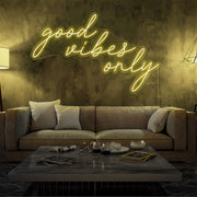 yellow good vibes only neon sign hanging on living room wall