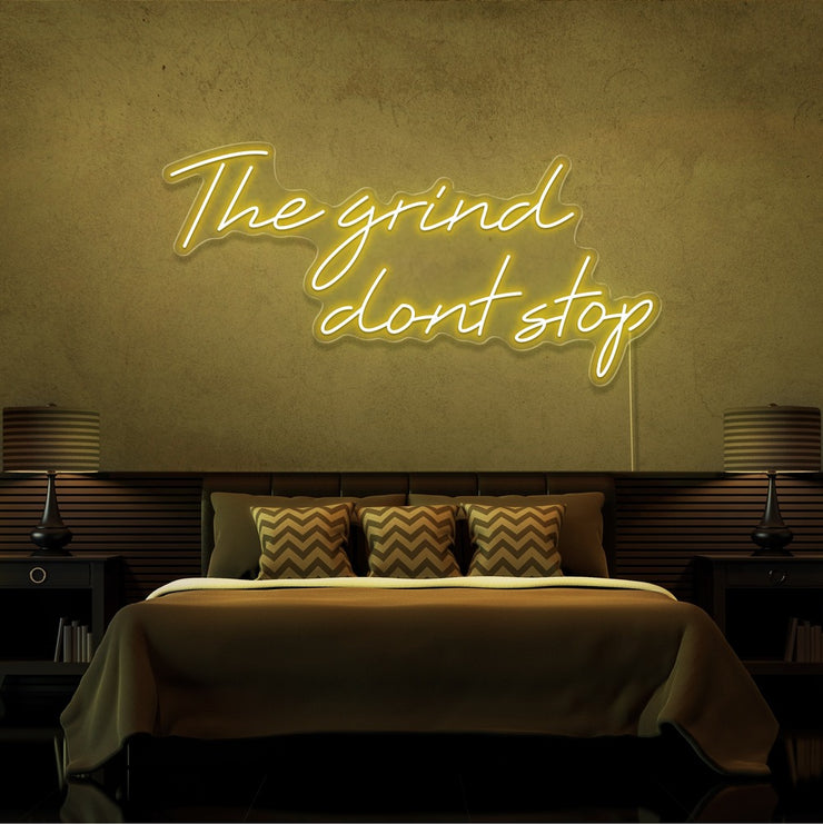 yellow the grind dont stop neon sign hanging on bedroom wall