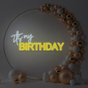 yellow it's my birthday neon sign hanging in gold hoop backdrop with balloons