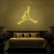 yellow jordan jumpman neon sign hanging on bedroom wall