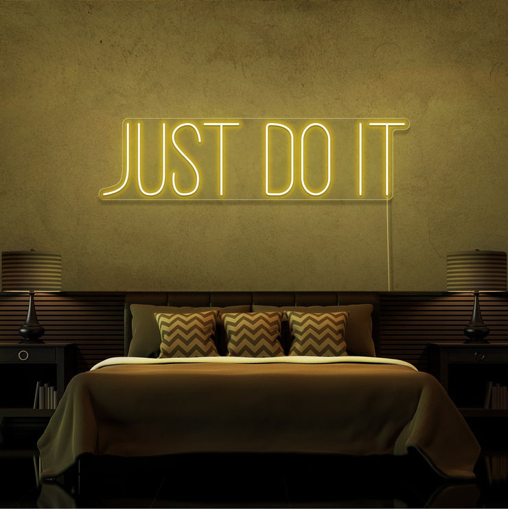 yellow just do it neon sign hanging on bedroom wall