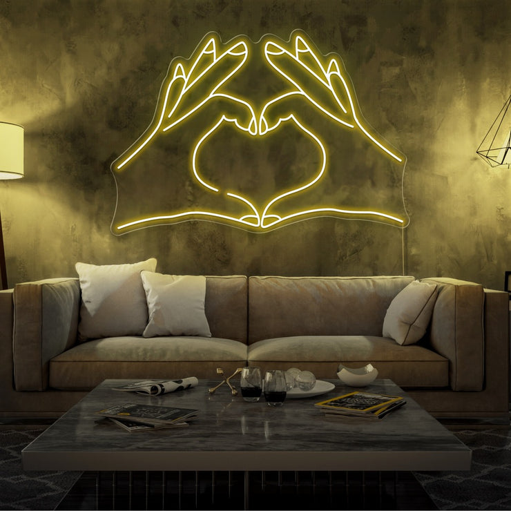 yellow love hands neon sign hanging on living room wall