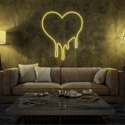 yellow melting heart neon sign hanging on living room wall