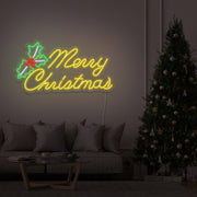 yellow merry chirstmas mistletoe neon sign hanging above couch next to christmas tree