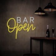 yellow open bar neon sign hanging on bar wall