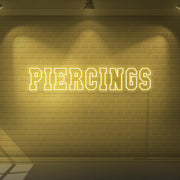 yellow piercings neon sign hanging on wall