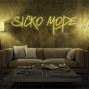 yellow sicko mode neon sign hanging on living room wall
