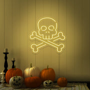 yellow skull bones neon sign with pumpkins on floor
