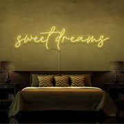 yellow sweet dreams neon sign hanging on bedroom wall