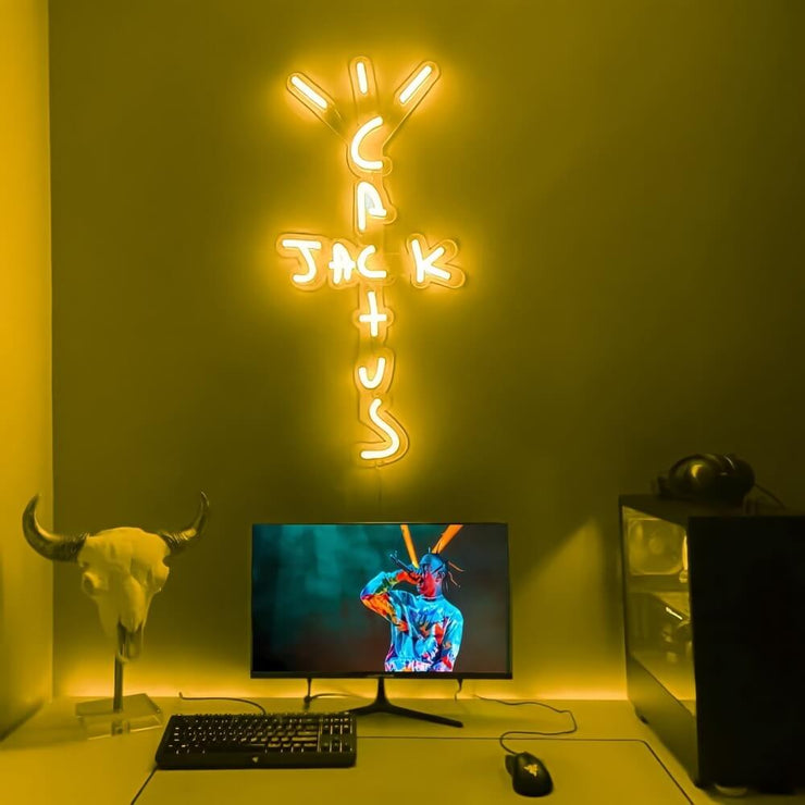 yellow travis Scott neon sign hanging on computer room wall