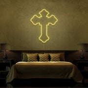 yellow tupac cross neon sign hanging on bedroom wall