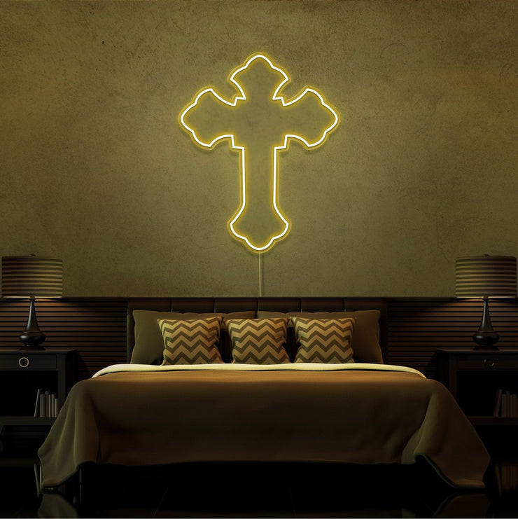 yellow tupac cross neon sign hanging on bedroom wall