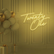 yellow  twenty one neon sign hanging on wall with balloons