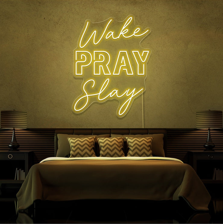 yellow wake pray slay neon sign hanging on bedroom wall