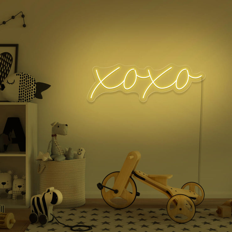 yellow xoxo neon sign hanging on kids bedroom wall